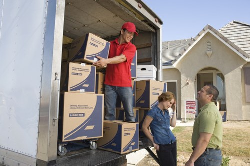 Professional movers carrying household items through a Sudbury property